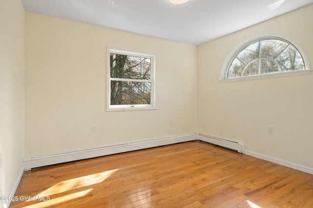 spare room featuring baseboards and wood finished floors