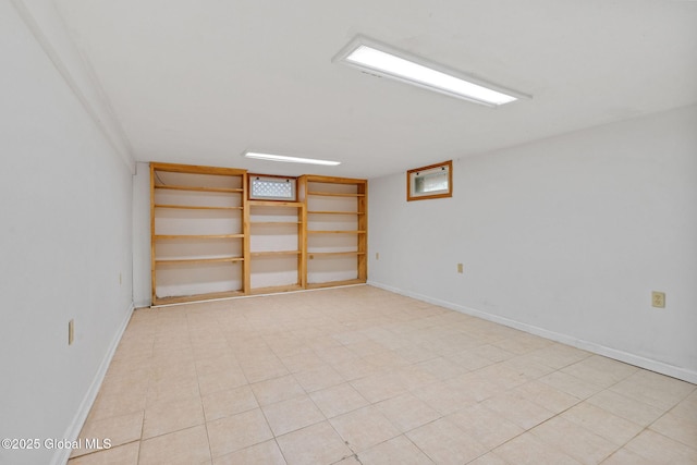 empty room with baseboards and built in shelves