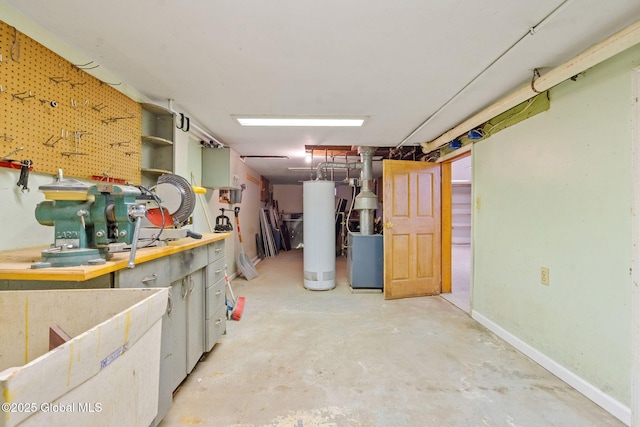 basement featuring water heater, a workshop area, and baseboards