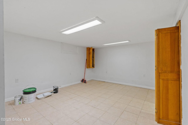 finished below grade area with baseboards and light tile patterned flooring