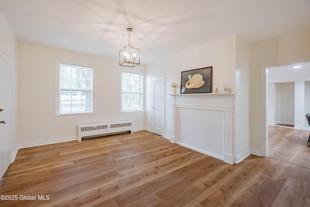 unfurnished dining area with radiator, a chandelier, light wood-style flooring, and baseboards