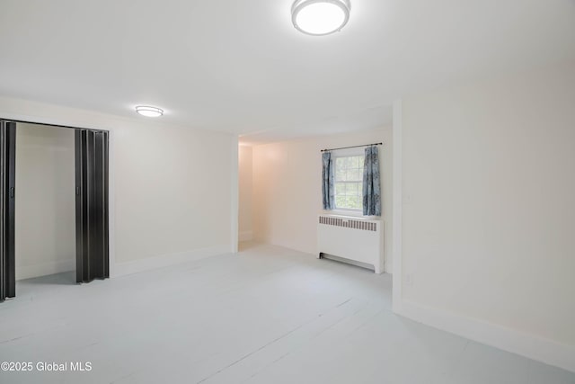 empty room with radiator and baseboards