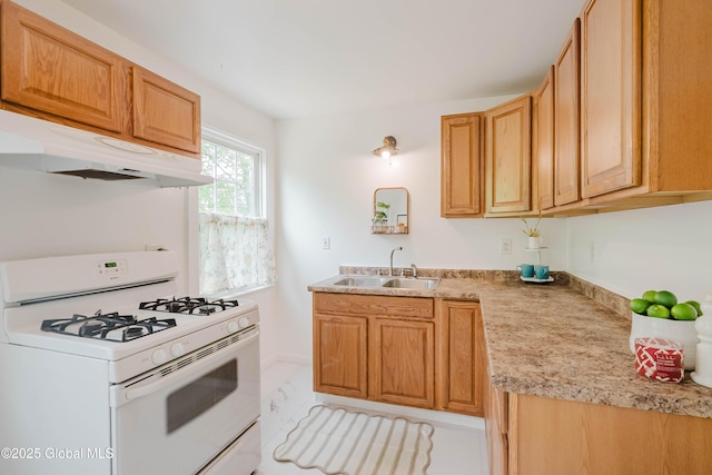 kitchen with white gas range oven, a sink, light countertops, and under cabinet range hood