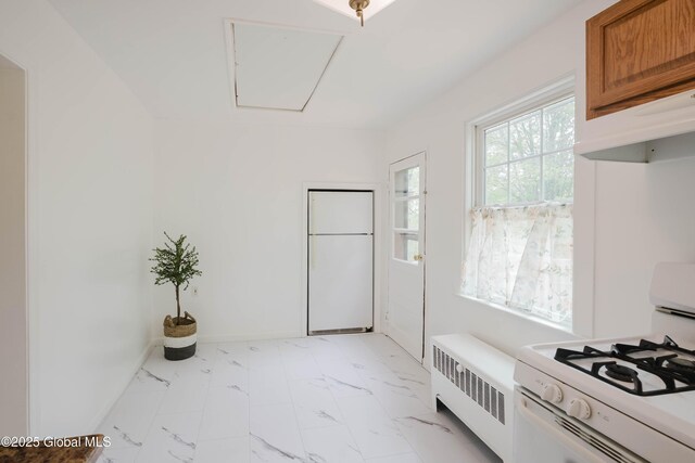 mudroom with radiator, attic access, and light marble finish flooring
