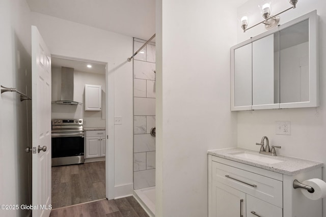 full bath with a shower stall, wood finished floors, and vanity