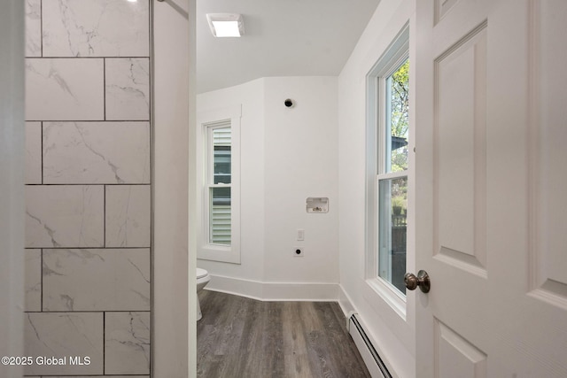 bathroom featuring baseboards, a baseboard radiator, toilet, and wood finished floors
