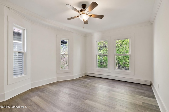 unfurnished room with crown molding, wood finished floors, baseboards, ceiling fan, and baseboard heating