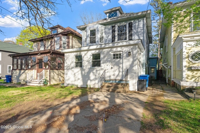 back of property with a sunroom and entry steps