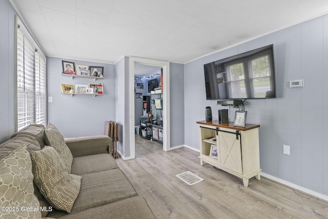 living area with baseboards, wood finished floors, and visible vents