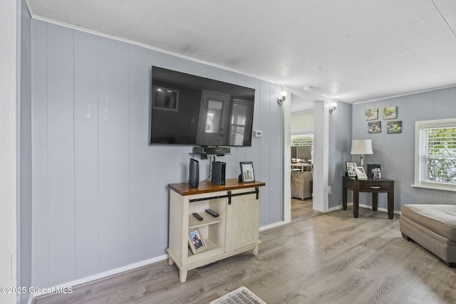 living area with baseboards and wood finished floors