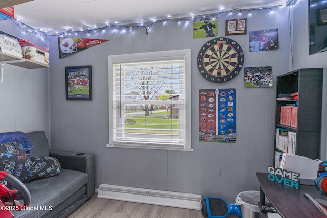 game room featuring plenty of natural light, track lighting, wood finished floors, and a baseboard radiator