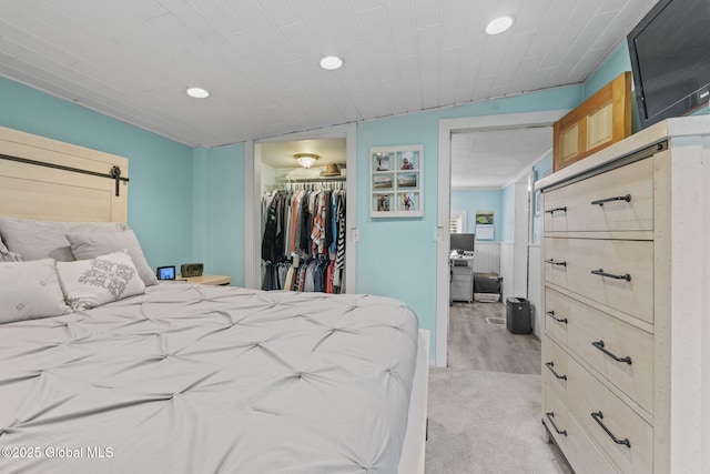 bedroom with recessed lighting, light wood finished floors, a spacious closet, and a closet