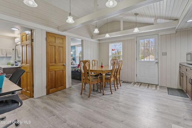 dining area with visible vents, vaulted ceiling with beams, and light wood-type flooring