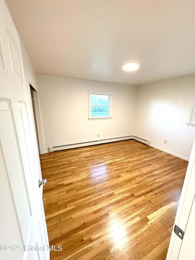 11 Mcdermott Rd, Mechanicville, NY 12118 - empty room featuring wood finished floors, a baseboard heating unit, baseboards, and baseboard heating
