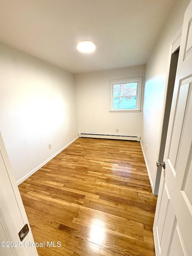 11 Mcdermott Rd, Mechanicville, NY 12118 - unfurnished bedroom featuring baseboard heating, light wood-style floors, and baseboards