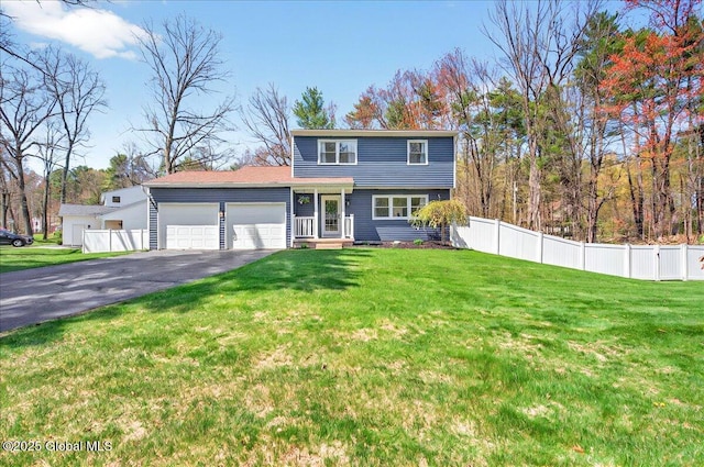 traditional-style house featuring fence, an attached garage, driveway, and a front lawn