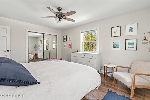 bedroom featuring baseboards, ceiling fan, wood finished floors, and a closet