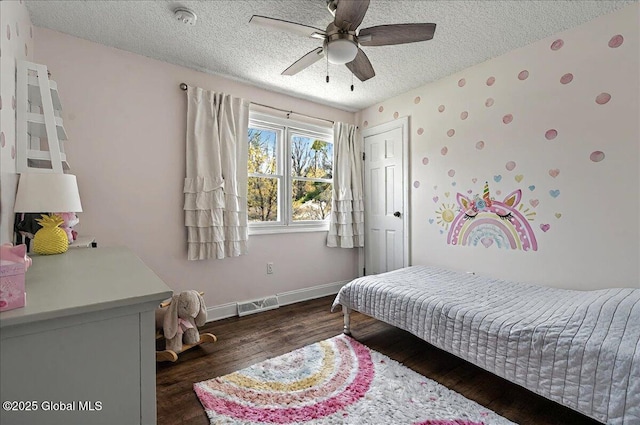 bedroom featuring a textured ceiling, a ceiling fan, baseboards, wood finished floors, and visible vents