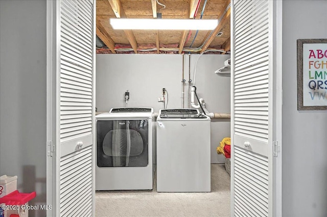 laundry room featuring laundry area, washing machine and dryer, and light carpet