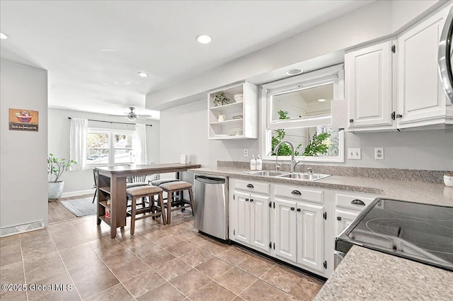 kitchen featuring stainless steel dishwasher, white cabinetry, a sink, and light countertops