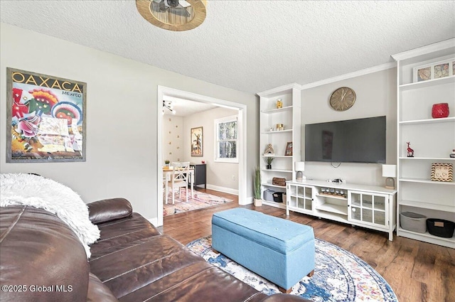 living room featuring baseboards, a textured ceiling, ceiling fan, and wood finished floors