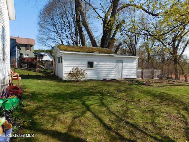 view of outdoor structure with fence and an outbuilding