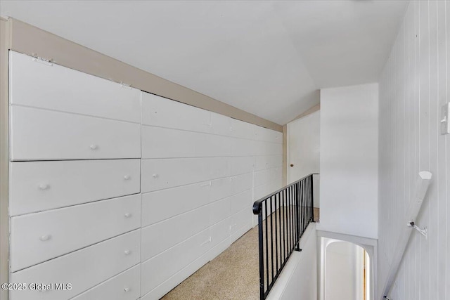hallway with vaulted ceiling and carpet floors