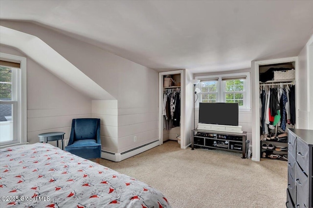 carpeted bedroom featuring multiple closets, a baseboard heating unit, and vaulted ceiling