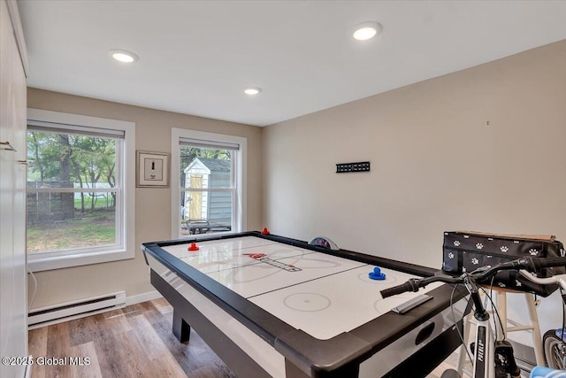 rec room with a baseboard heating unit, wood finished floors, recessed lighting, and baseboards