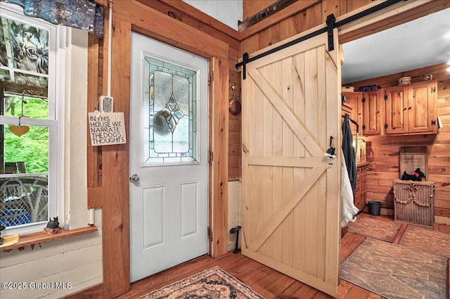 291-294 Gilchrist Hill Rd, Hartford, NY 12838 - foyer entrance featuring a barn door, wooden walls, light wood-style floors, and healthy amount of natural light