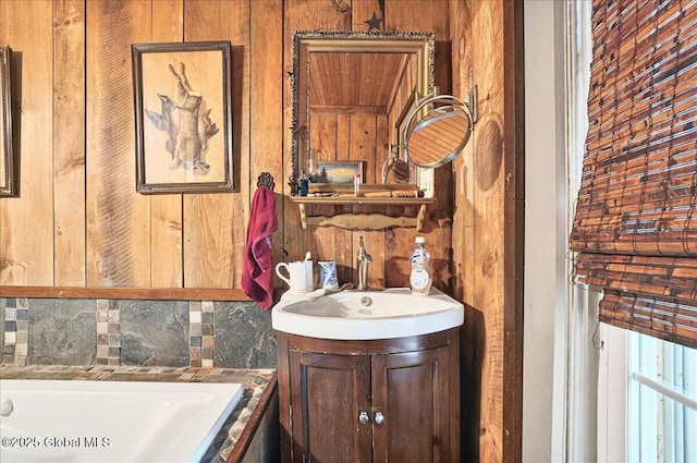 291-294 Gilchrist Hill Rd, Hartford, NY 12838 - bathroom featuring a relaxing tiled tub, wood walls, vanity, and decorative backsplash