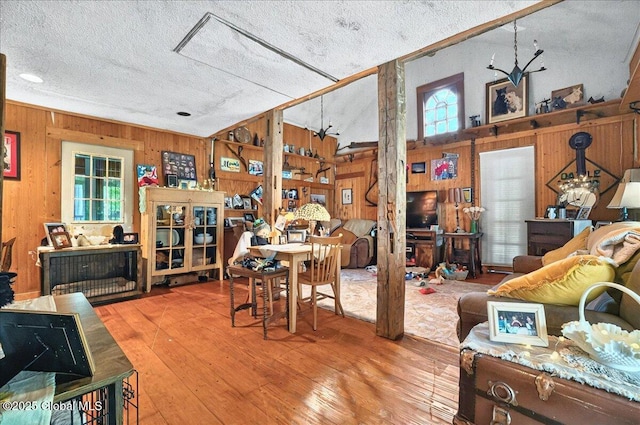 291-294 Gilchrist Hill Rd, Hartford, NY 12838 - dining space featuring wooden walls, healthy amount of natural light, a textured ceiling, and hardwood / wood-style floors
