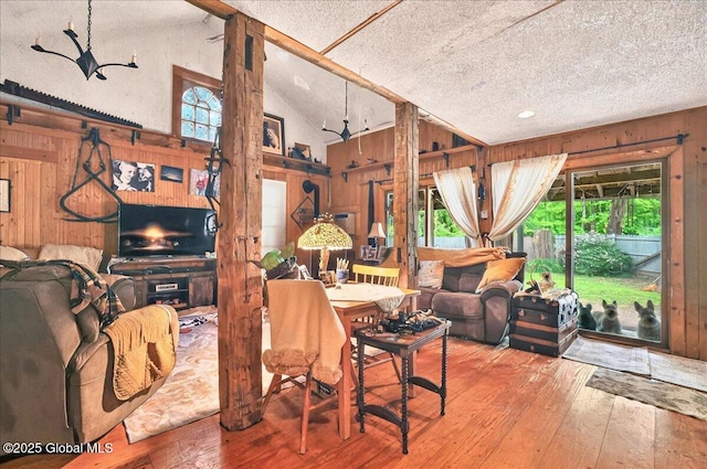291-294 Gilchrist Hill Rd, Hartford, NY 12838 - living area with wooden walls, healthy amount of natural light, a textured ceiling, hardwood / wood-style floors, and lofted ceiling