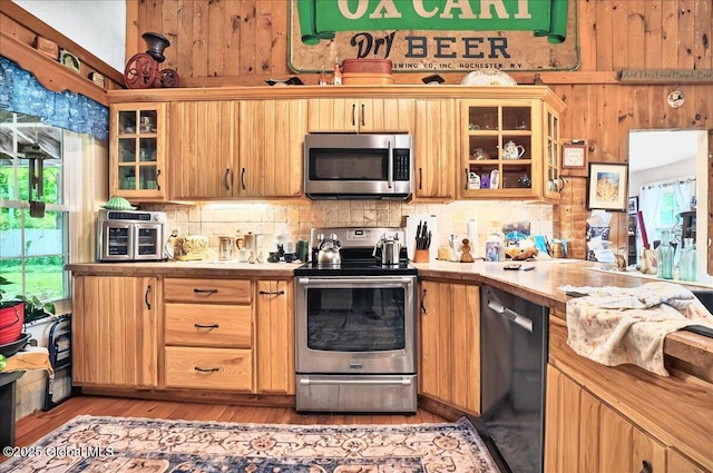 291-294 Gilchrist Hill Rd, Hartford, NY 12838 - kitchen with stainless steel appliances, decorative backsplash, light countertops, light wood finished floors, and glass insert cabinets