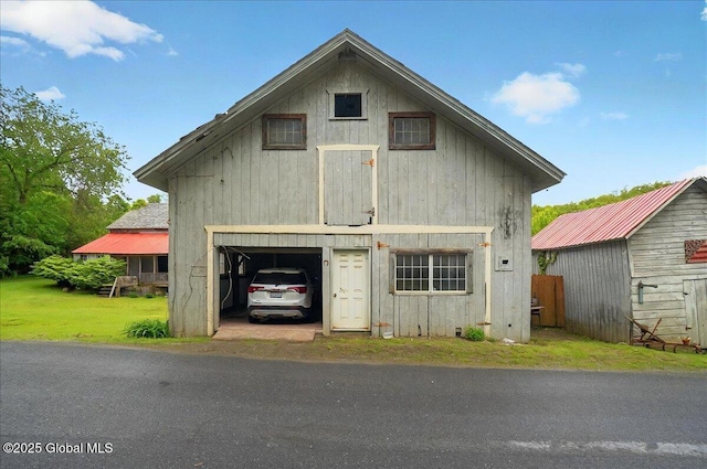 291-294 Gilchrist Hill Rd, Hartford, NY 12838 - view of front of house with driveway, a detached garage, a front lawn, and an outbuilding
