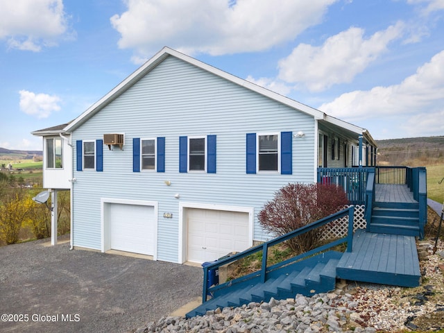 exterior space with a garage, a wall unit AC, and driveway