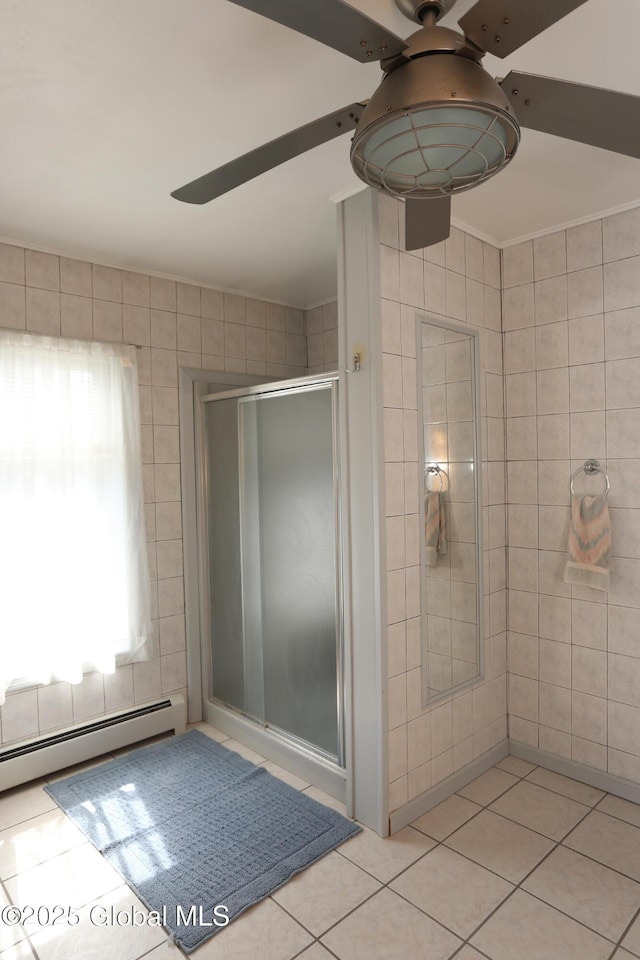 bathroom with a ceiling fan, baseboard heating, tile patterned flooring, and a stall shower