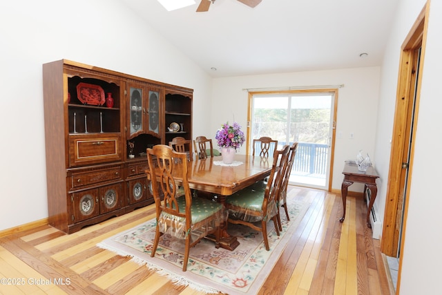 dining space featuring a ceiling fan, light wood finished floors, a baseboard heating unit, and lofted ceiling