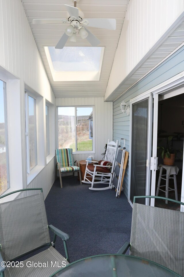 sunroom / solarium with a ceiling fan and a skylight