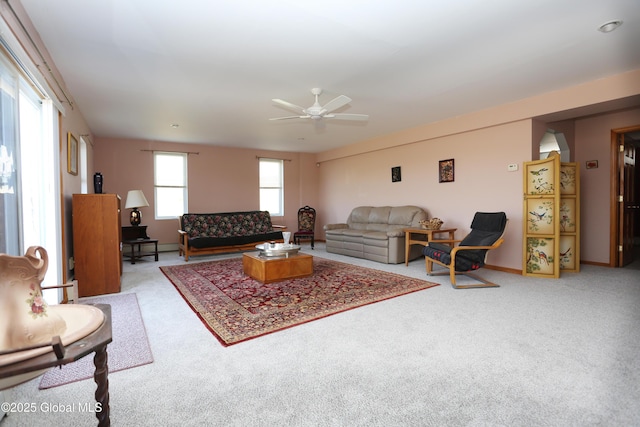 carpeted living area featuring baseboards and a ceiling fan
