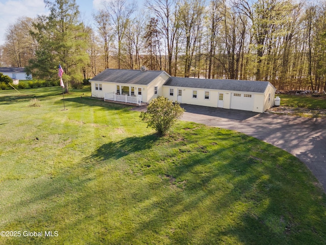 view of front of house with a garage, aphalt driveway, and a front lawn