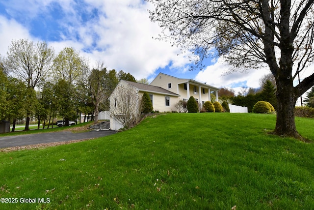 view of home's exterior with a lawn and aphalt driveway