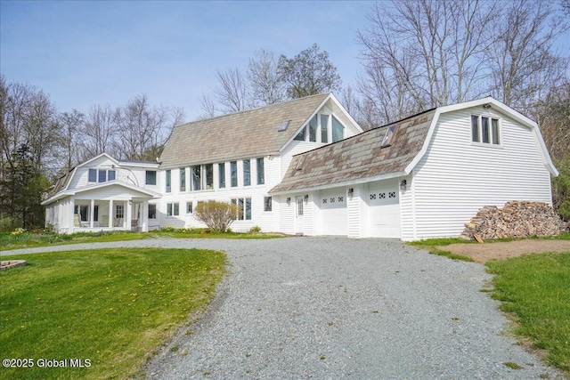 view of front of home with driveway, a gambrel roof, and a front yard