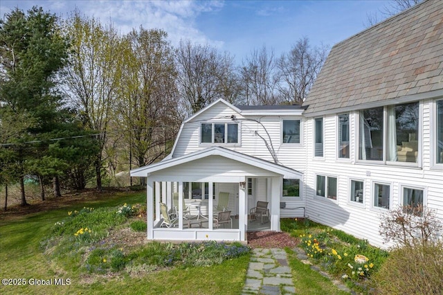 exterior space featuring a sunroom and a front yard