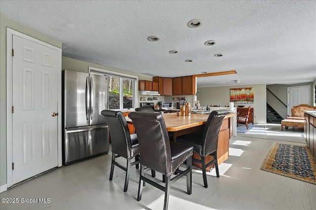 dining area featuring a textured ceiling and stairs