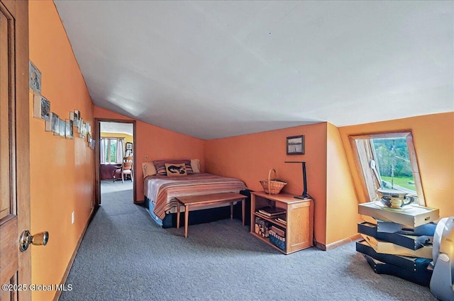 carpeted bedroom featuring baseboards and lofted ceiling