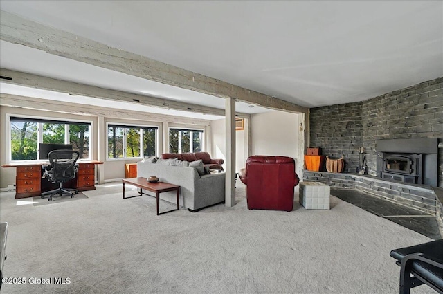 carpeted living room with a wood stove and beamed ceiling