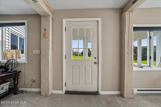 entryway with baseboards, a baseboard heating unit, a wealth of natural light, and carpet
