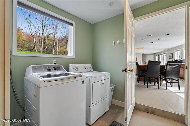 laundry area featuring laundry area, independent washer and dryer, visible vents, and light wood-type flooring