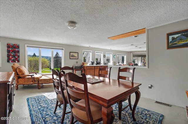 dining room featuring a textured ceiling and visible vents
